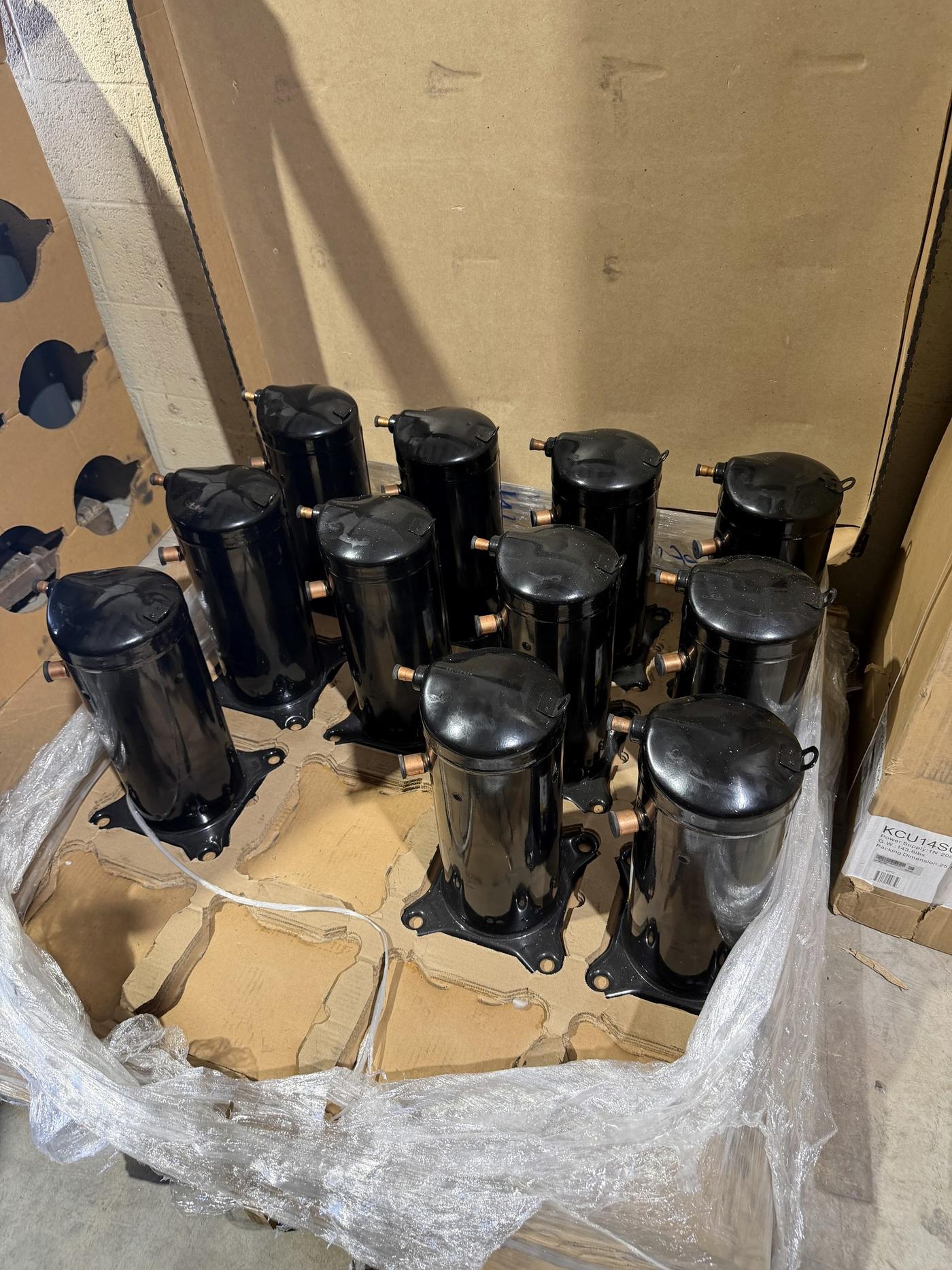 Scroll compressors on a pallet at Banos HVAC Supply