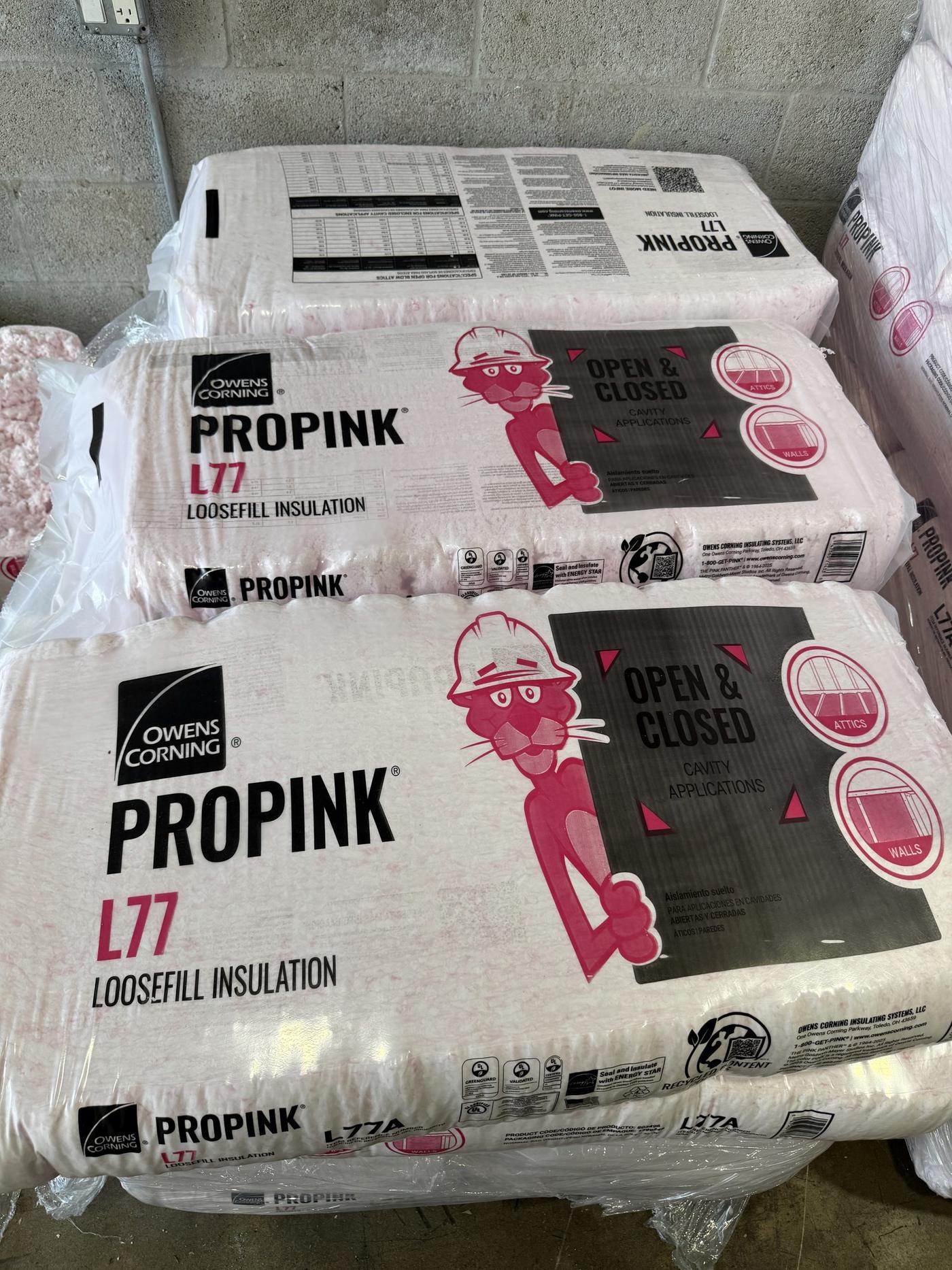 Bags of Owens Corning ProPink loosefill insulation ready for installation by the Banos HVAC team