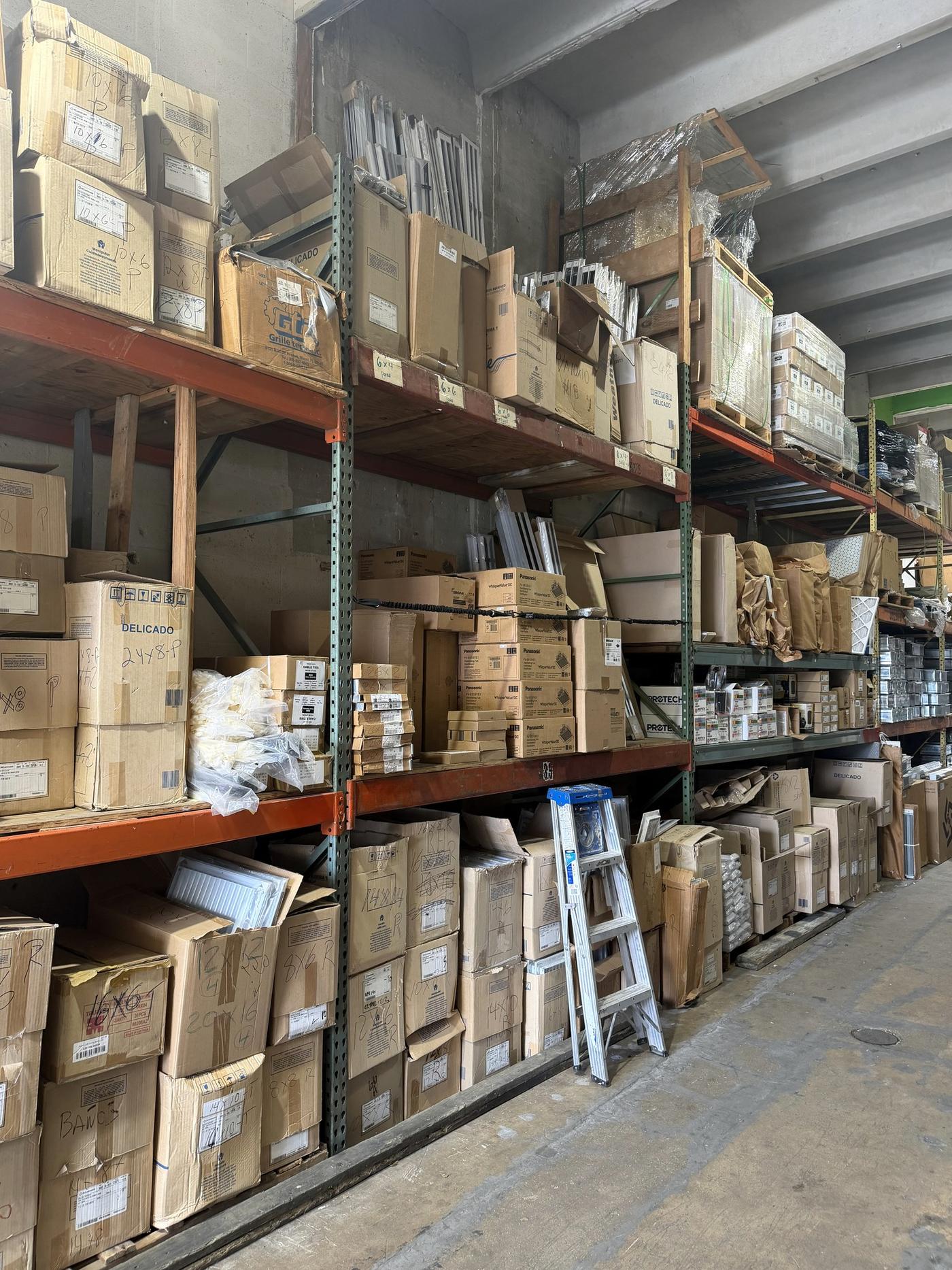 Shelving stocked with HVAC parts and supplies at the Banos HVAC warehouse in Hialeah